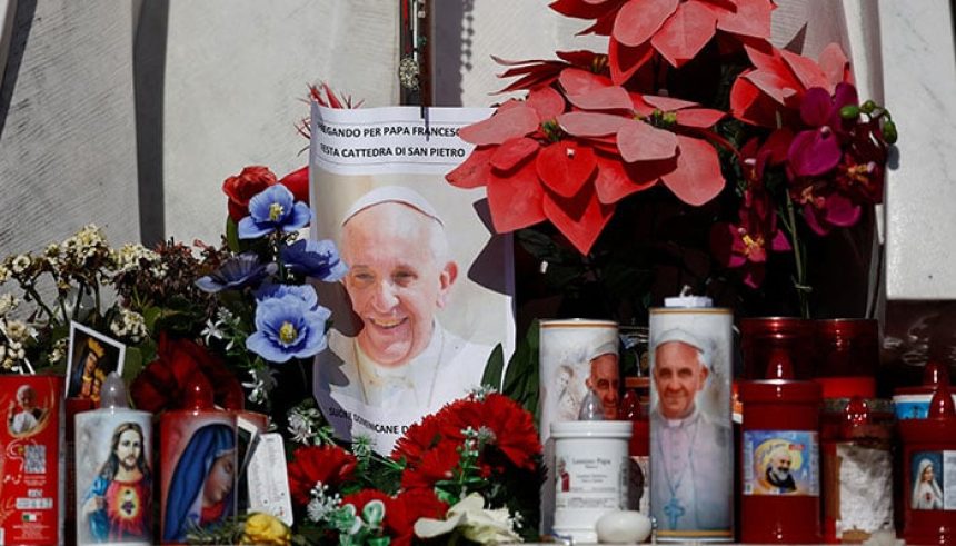 Decorated candles, flowers, and pictures of Pope Francis sit next to the statue of the late Pope John Paul II outside Gemelli Hospital, where Pope Francis is admitted for treatment, in Rome, Italy, on February 22, 2025. — Reuters