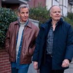 Two middle-aged men walking down pavement on residential road