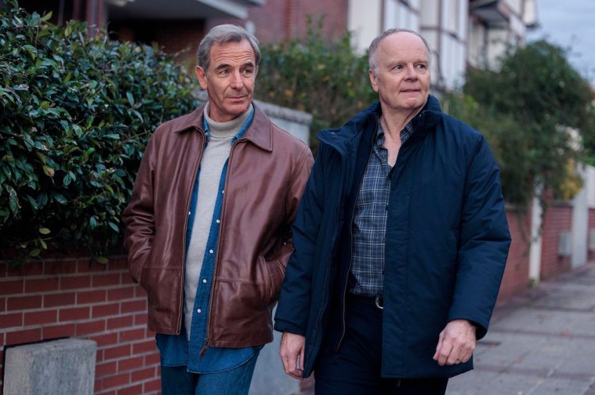 Two middle-aged men walking down pavement on residential road