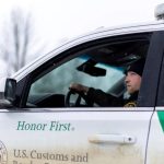 A US Border Patrol agent sits in a marked SUV near the Canada border.