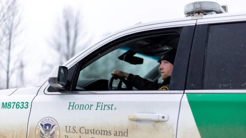 A US Border Patrol agent sits in a marked SUV near the Canada border.