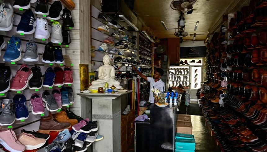 A man waits for customers at a dimmed footwear shop during a nationwide power outage in Galle on February 9, 2025. — AFP