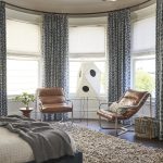 bedroom with lots of natural light, two brown leather armchairs, curtains over sheers and a shag rug