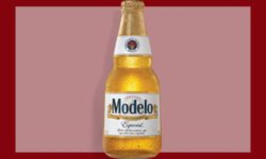 A bottle of Modelo beer on a bordered maroon background.