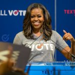 Michelle Obama speaking at podium smiling