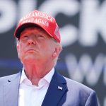 Donald Trump wearing a red make america great again hat